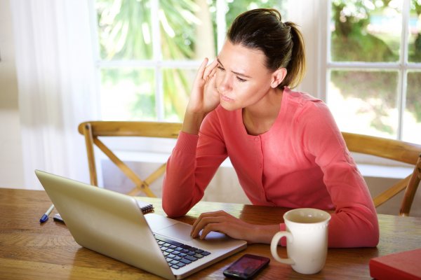 advanced system repair system optimizers woman in red blouse in front of laptop wondering